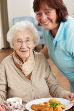 elderly woman being served a meal