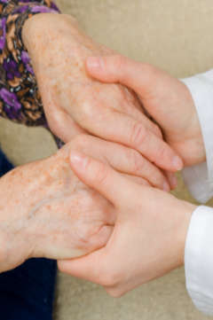 nurse holding an elderly patient's hands