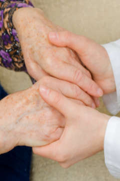 nurse holding an elderly patient's hands 