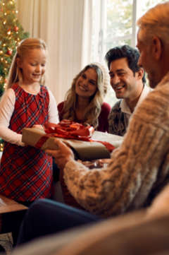 Little girl giving her grandfather a Christmas present 