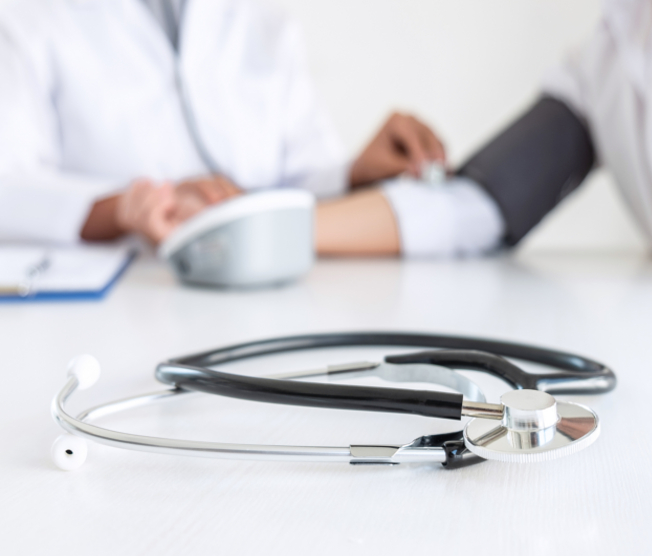 doctor taking patient's blood pressure