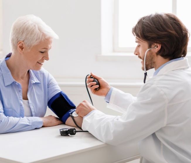 doctor taking an older woman's blood pressure