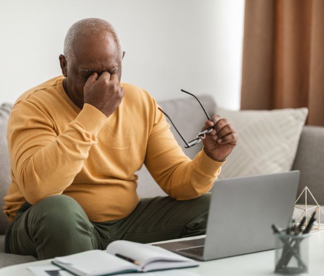 older man rubbing face from eye strain