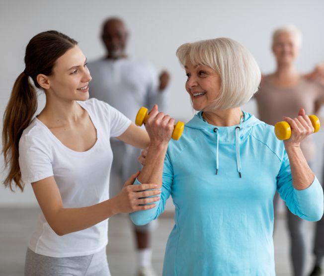 fitness coach helping senior woman exercise