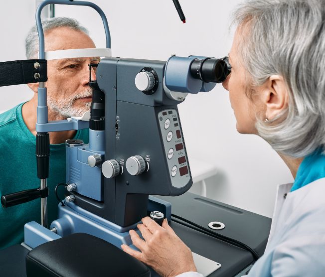 optometrist performing eye exam on senior man
