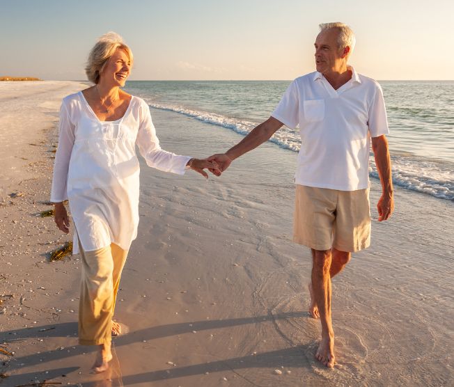 senior couple walking on the beach