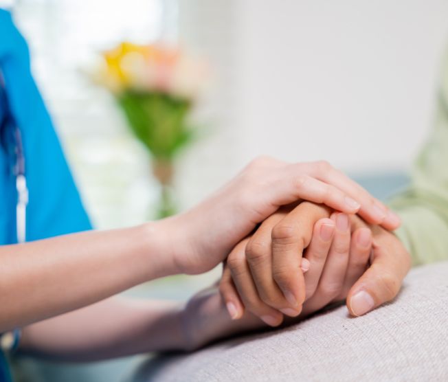 nurse holding hands of senior man