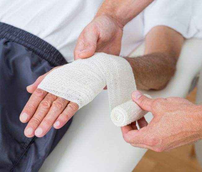 doctor bandaging patient's hand