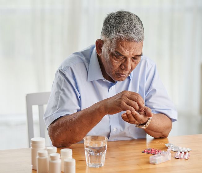 older man sorting his medications