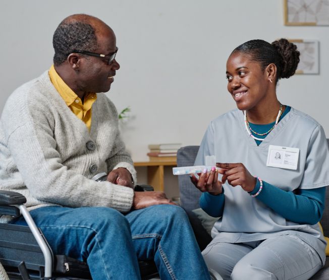 nurse giving pills to male senior patient