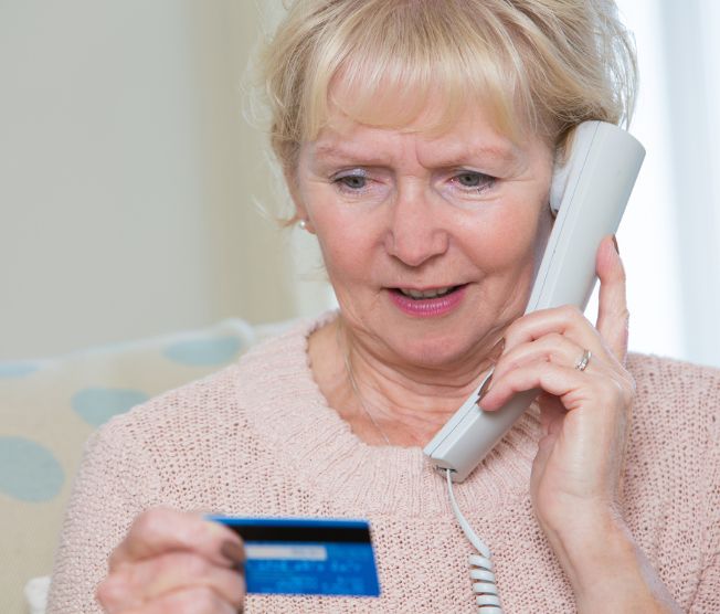 senior woman giving credit card details on the phone