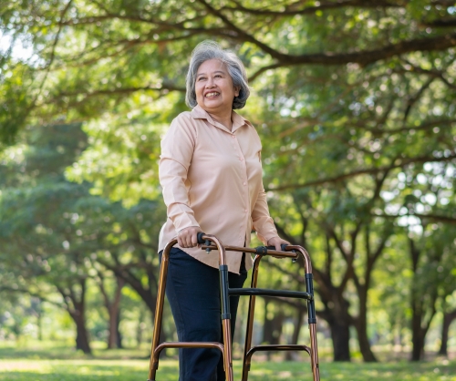 elderly woman uses a walker outside