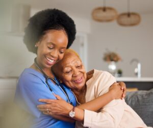 young caregiver comforts senior woman